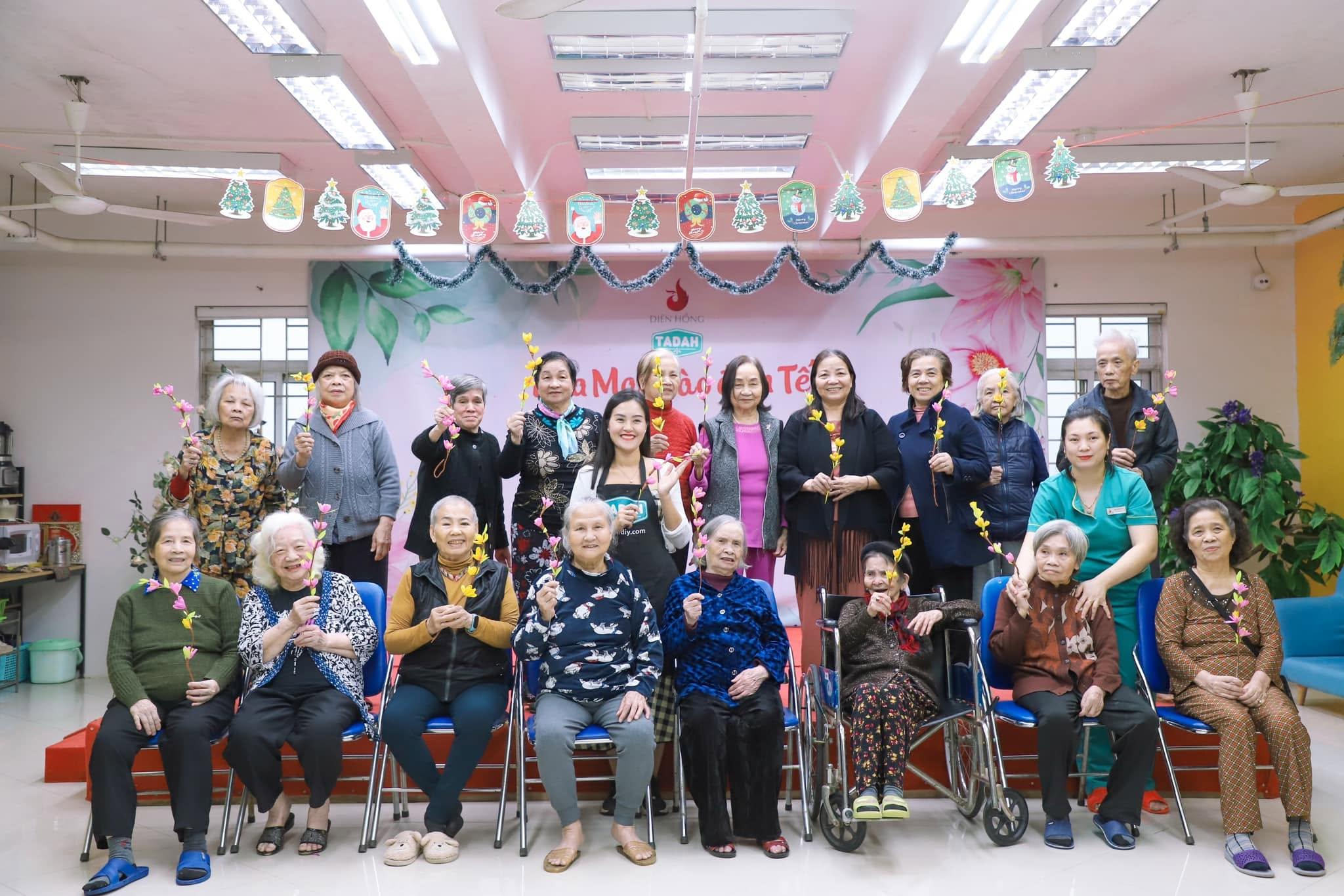 Gần hai mươi người cao tuổi tại Diên Hồng cùng cầm cành hoa giấy tự làm, trong chương trình đón Tết do Tadah tổ chức